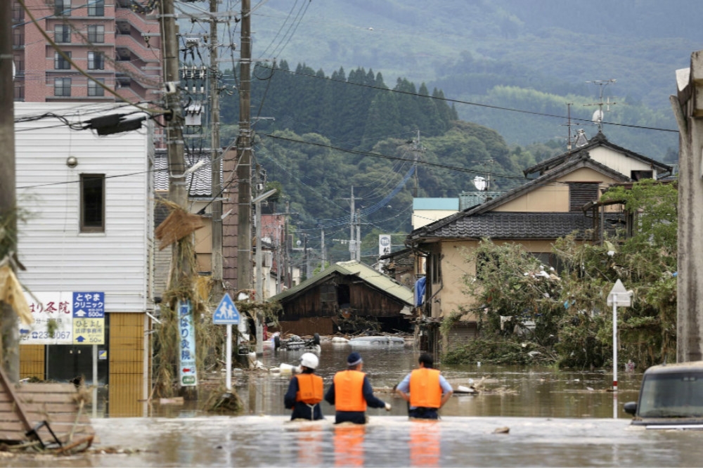 日北熊本縣球磨川河水暴漲淹沒民宅。（湯森路透）