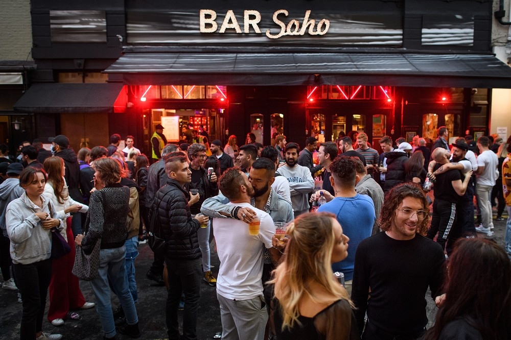 睽違3個多月才解封的「超級星期六」，民眾群聚在英國倫敦的酒吧外圍。（湯森路透）