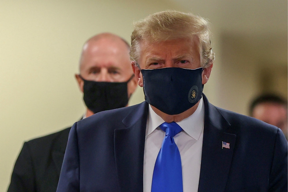 抵達華府軍方醫療中心，川普終於首次在公眾場所戴上口罩。（湯森路透）