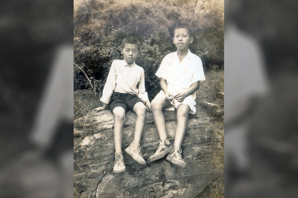 1950年，王正中與王正方兄弟坐在大石頭前合影。（圖片由作者提供）