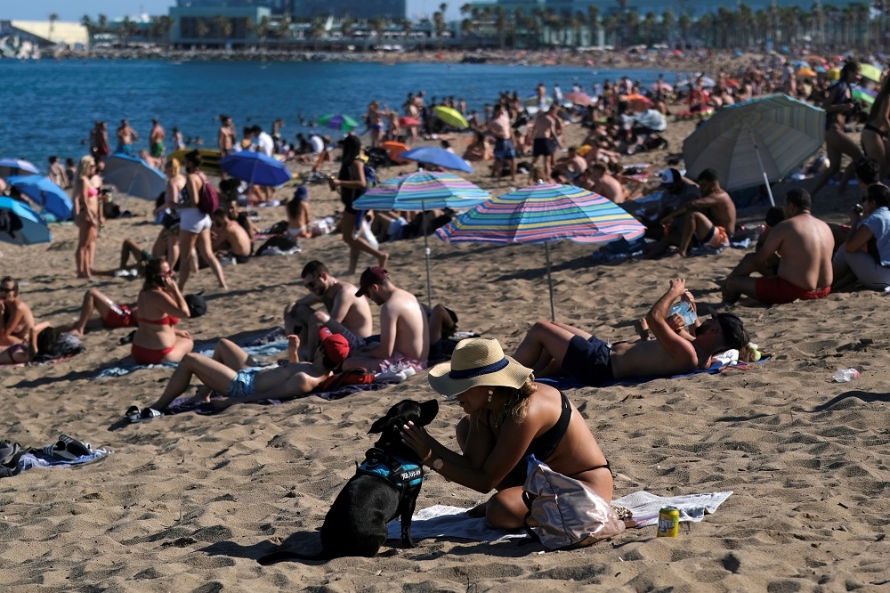 西班牙民眾在巴塞隆納海灘享受夏日。（湯森路透）