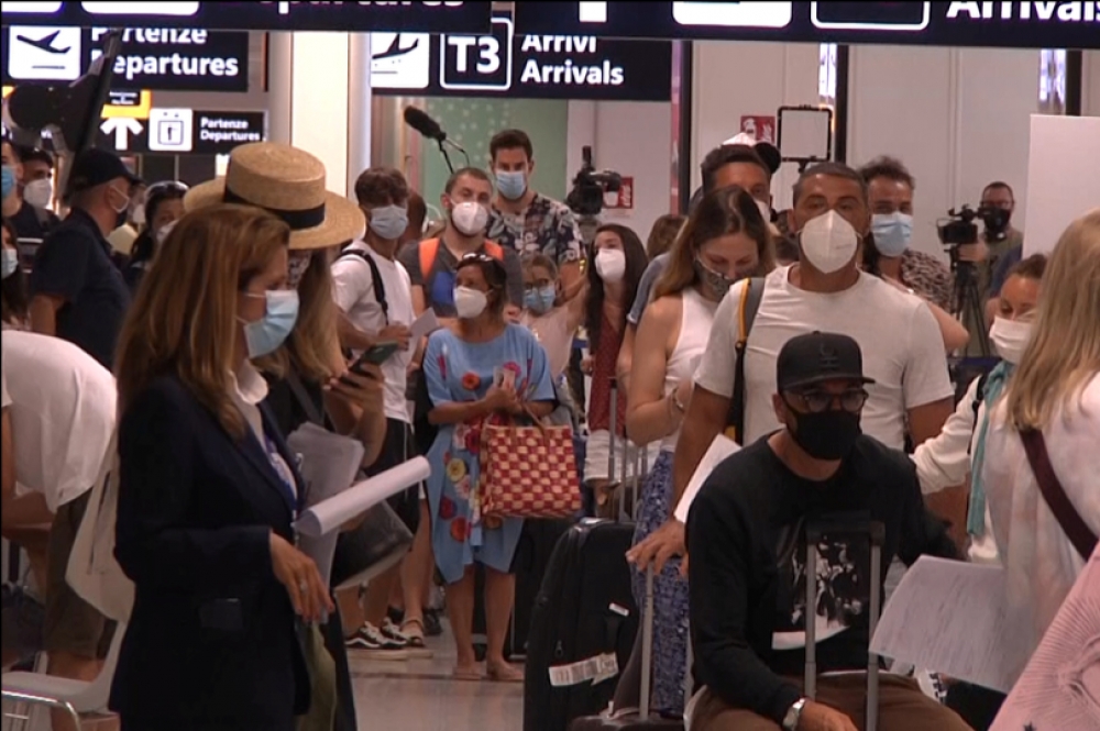 旅客在義大利羅馬菲烏米奇諾（Fiumicino）機場排隊接受新冠病毒測試。（湯森路透）