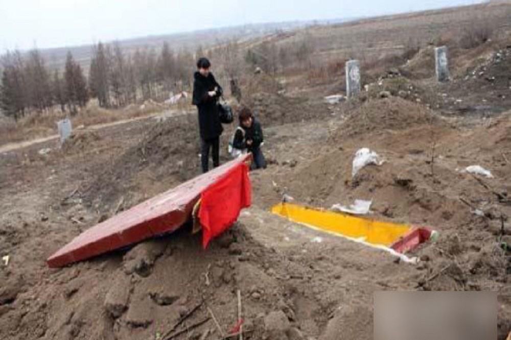 兩名死者家屬在被挖走遺體的墓地前（寒冬）