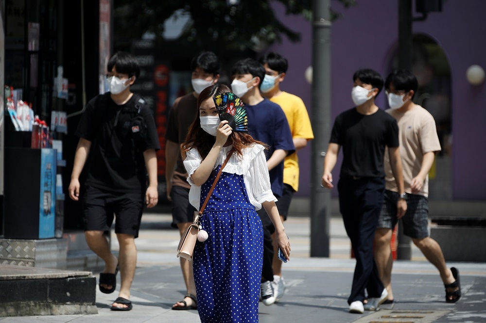 考量疫情未歇，首爾街頭行人多半仍戴上口罩。（湯森路透）
