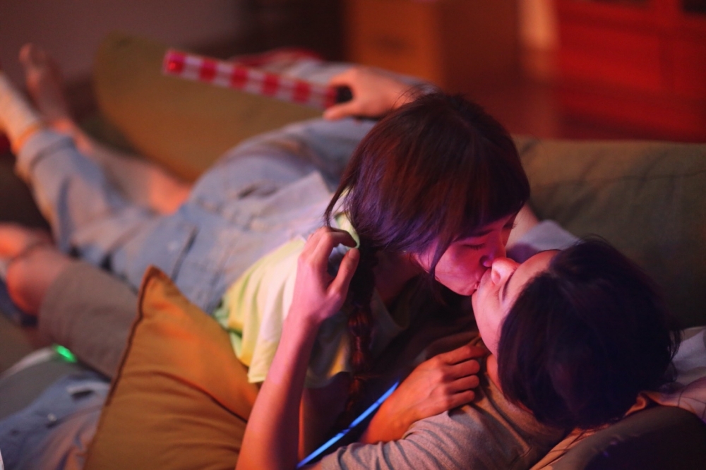 Lulu（左）在剛推出的〈搬家〉MV獻出螢幕初吻，撲倒男主角林哲熹。（環球音樂提供）
