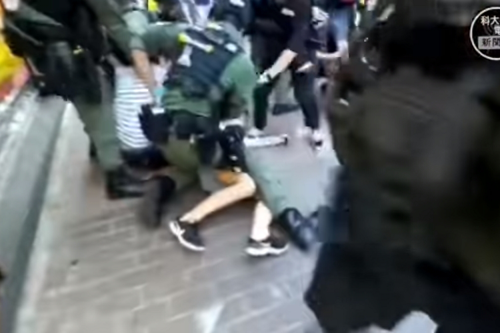 西洋菜南街一名12歲少女遭到港警跨坐制伏。（擷取自臉書「科大電台新聞組 HKUST Radio News Reporting Team」影片）