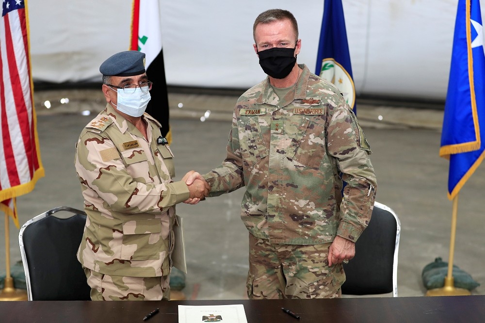 美國聯合特遣隊－堅決行動（Combined Joint Task Force-Operation Inherent Resolve）副指揮官艾可曼（ Kenneth P. Ekman）在交接儀式上，與伊拉克准將薩拉（Salah Abdullah）握手，攝於伊拉克巴格達。
