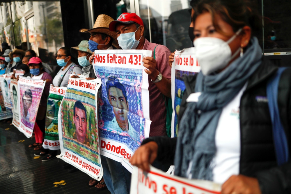 墨西哥失蹤學生家屬拿著畫面上街，要求政府協尋他們的子女下落。（湯森路透）