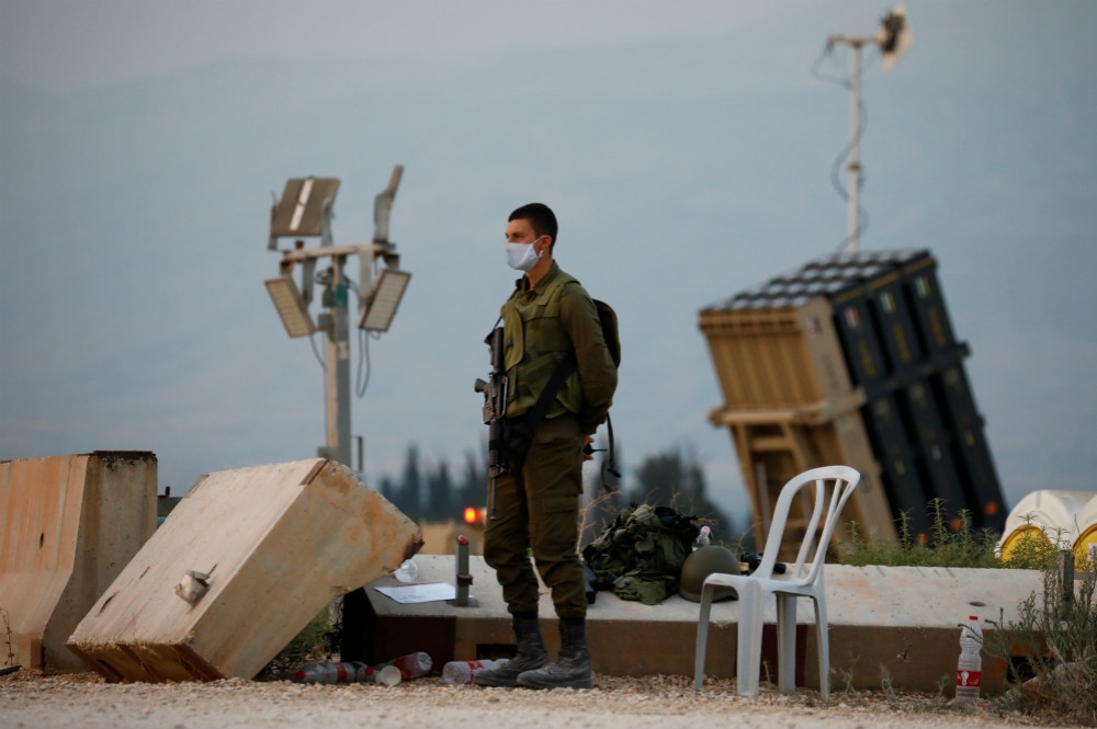 駐紮邊境的以色列士兵與知名「鐵穹」防空系統（右後）。（湯森路透）