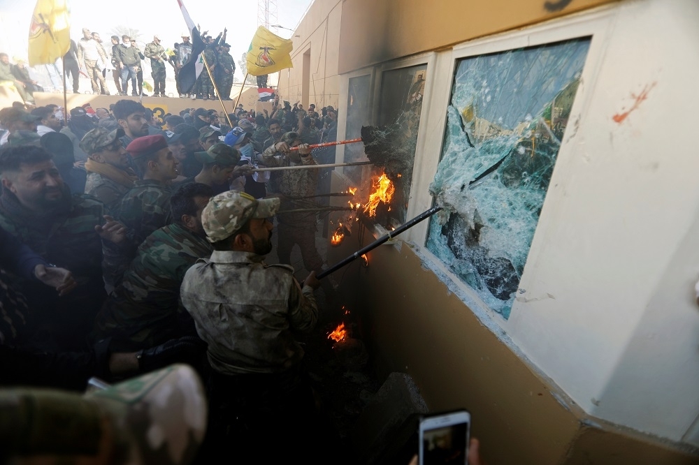 2020年1月民兵組織支持者包圍美國駐巴格達大使館，朝內部發火和投擲汽油彈攻擊。（湯森路透）