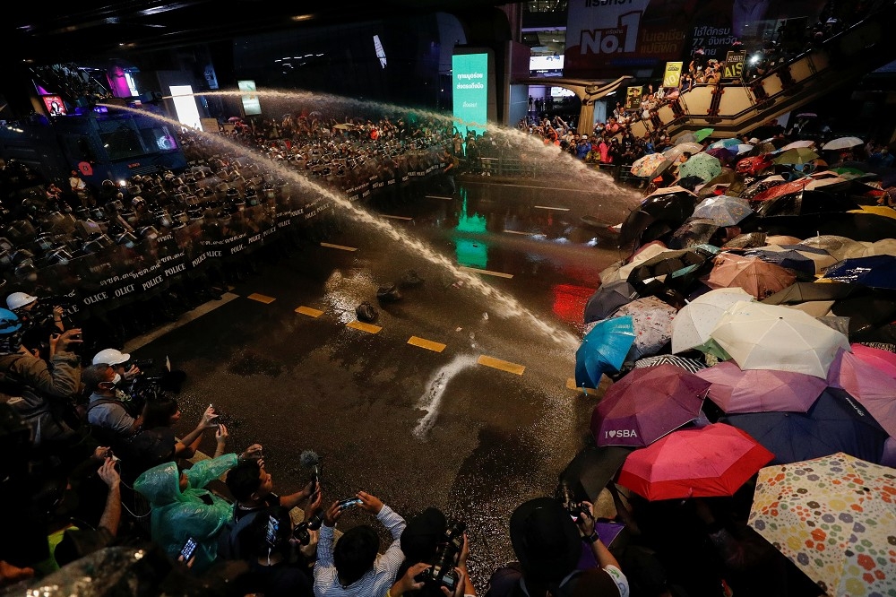 16日泰國當地時間晚間警方與抗議群眾對峙，警方動用水柱驅散群眾。（湯森路透）