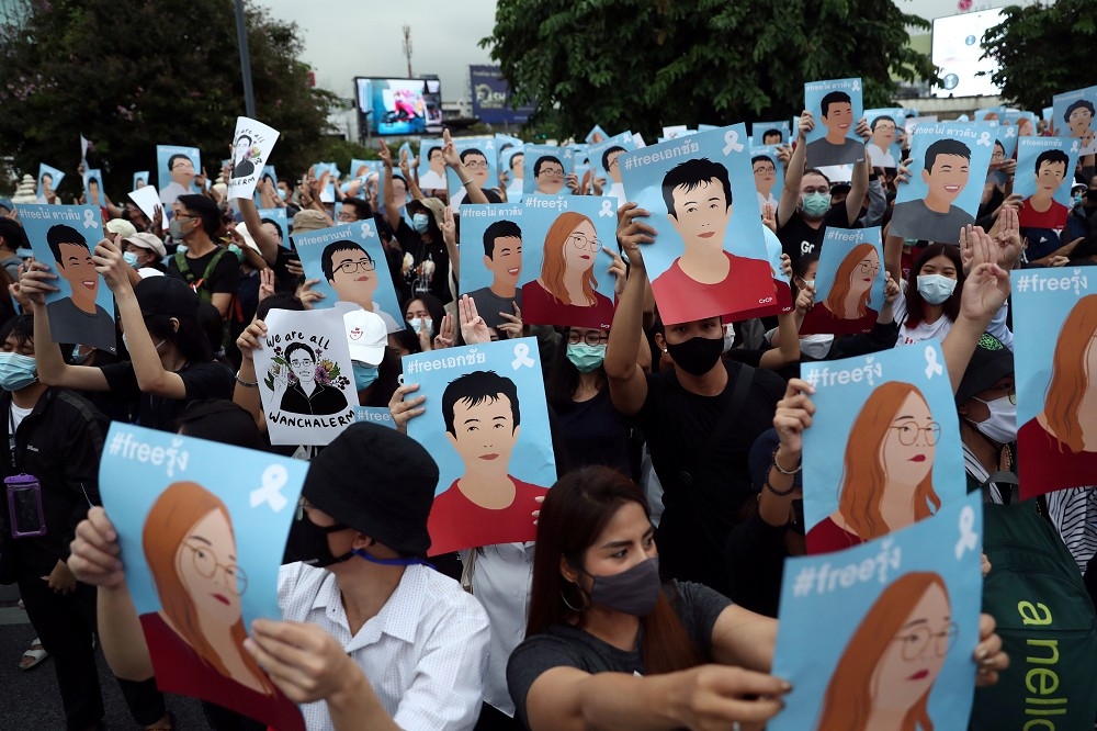 泰國抗議群眾舉起被抓抗議領袖的海報，要求政府釋放。（湯森路透）