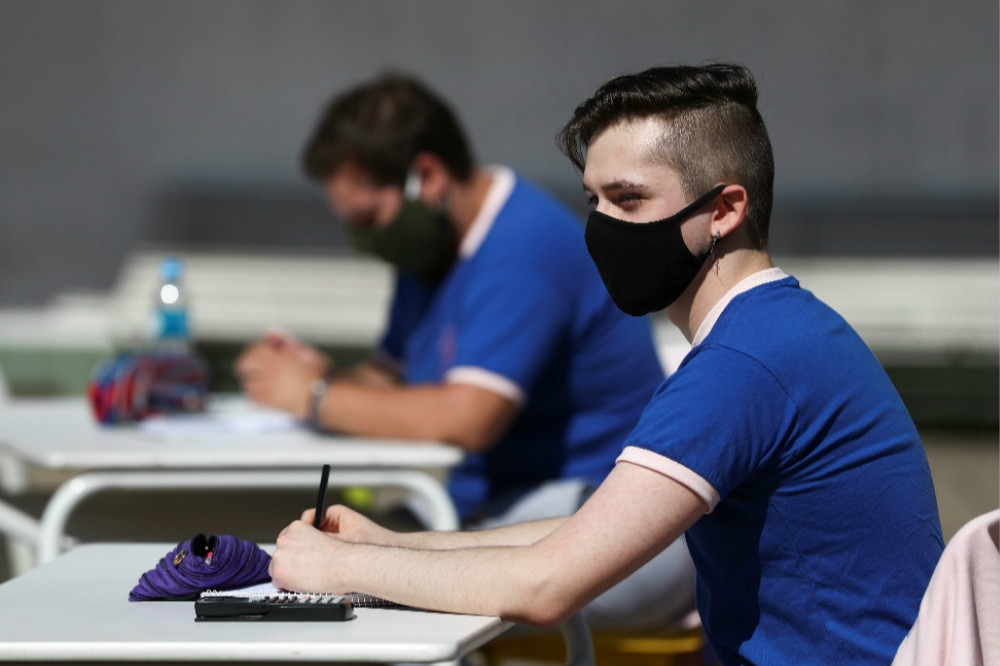 戴口罩、在戶外進行考試的阿根廷學生。（湯森路透）