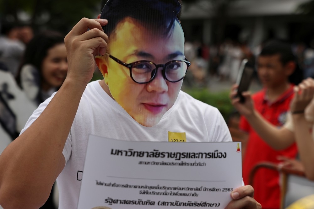 泰國抗議者舉起流亡學者Pavin Chachavalpongpun的頭像。（湯森路透）