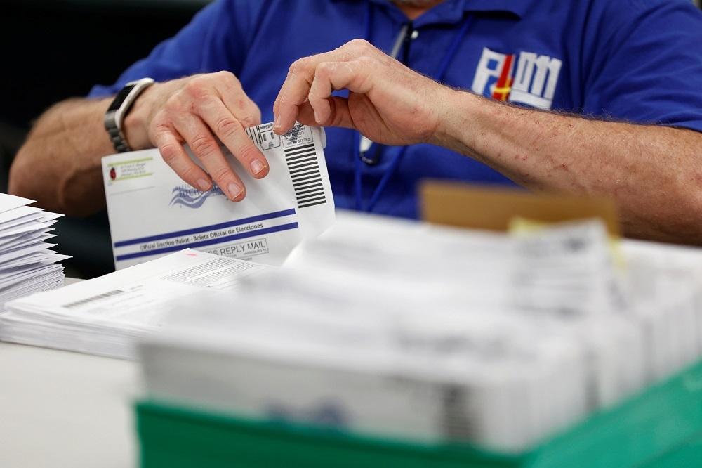 選委會官員正在計算回收後的郵寄選票。（湯森路透）