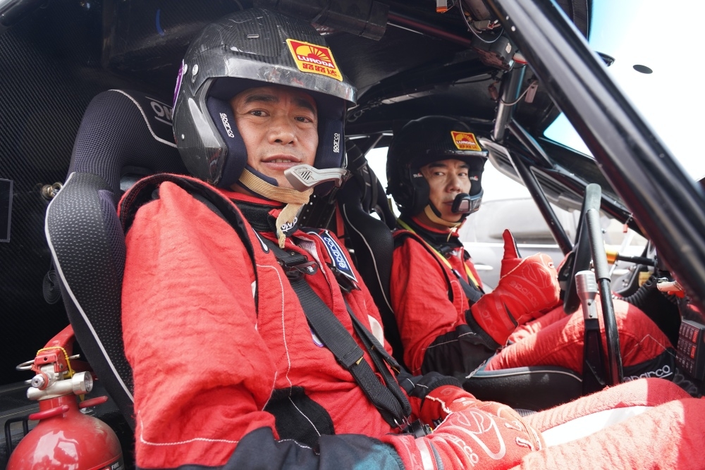 任賢齊（右）內蒙沙漠拍MV，親自上陣駕駛越野賽車。（寰亞音樂提供）