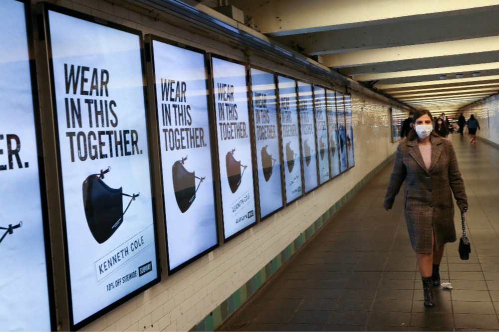 紐約市地鐵站張貼，呼籲民眾戴上口罩防疫的廣告。（湯森路透）