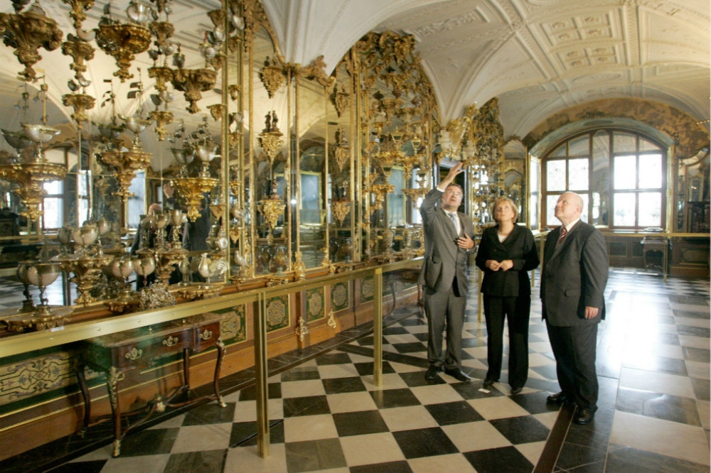 綠穹珍寶館館方向德國總理梅克爾（中央）介紹內部展品。（湯森路透）
