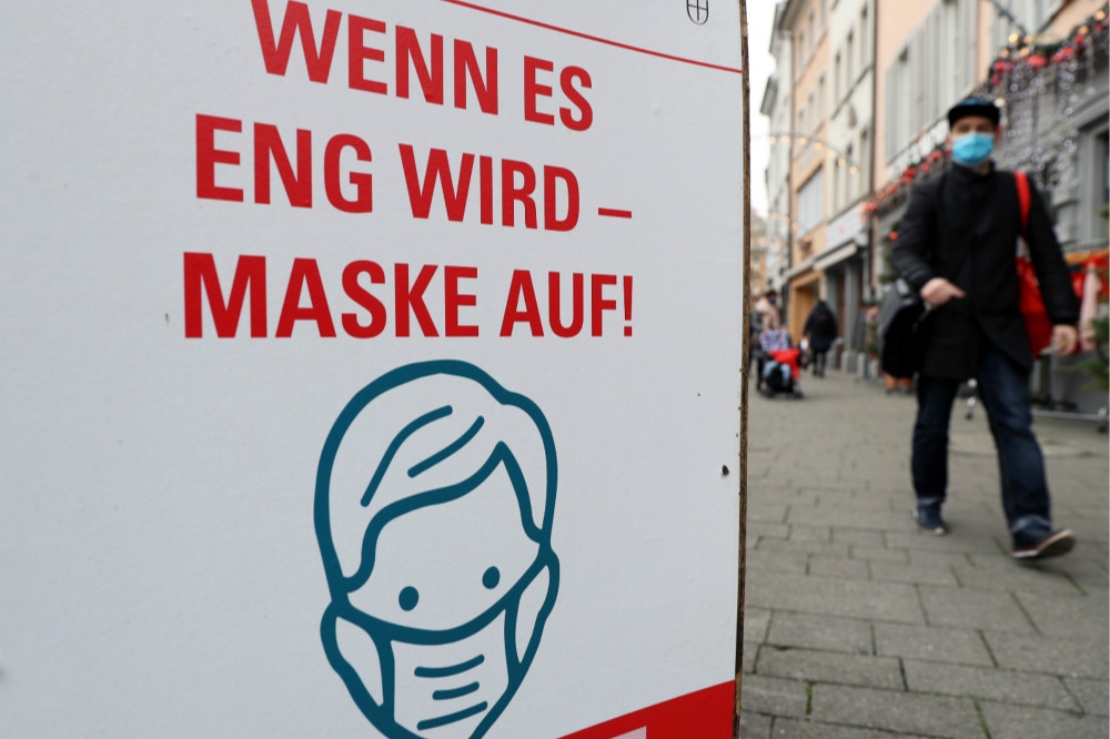 德國街道上提醒民眾外出戴口罩的海報。（湯森路透）