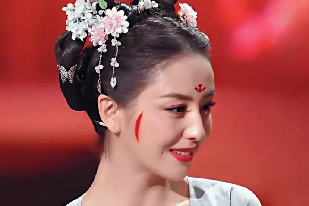 電視劇《國家寶藏》中，演員佟麗婭復原唐妝，在臉頰上清楚可見一道「斜紅」。（取自百度百科）