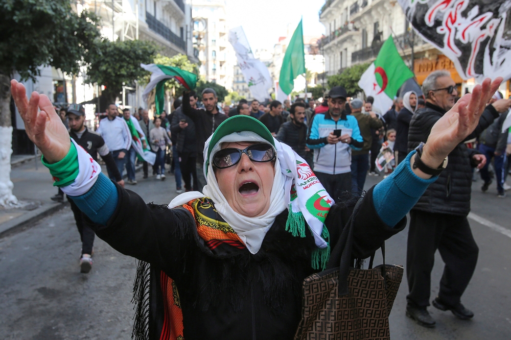 阿爾及利亞萬人抗爭一周年，一名婦女擺出手勢。（湯森路透）