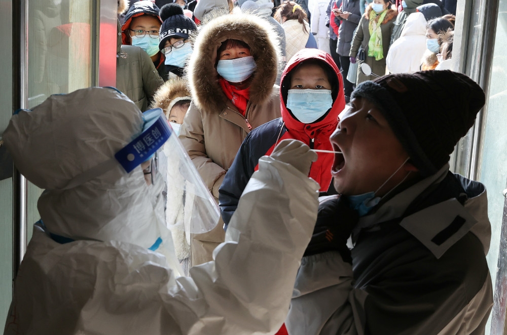 為確保北京安全，進京道路自元月初起就進行交通管制，通勤族必須持核酸檢測證明才能進入市區；圖為北京市民眾排隊接受新冠肺炎篩檢。（湯森路透）