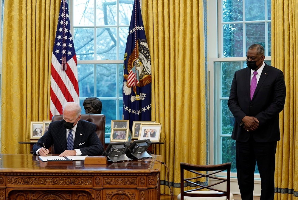 美國總統拜登與國防部長奧斯汀在白宮橢圓辦公室簽署行政命令。（湯森路透）