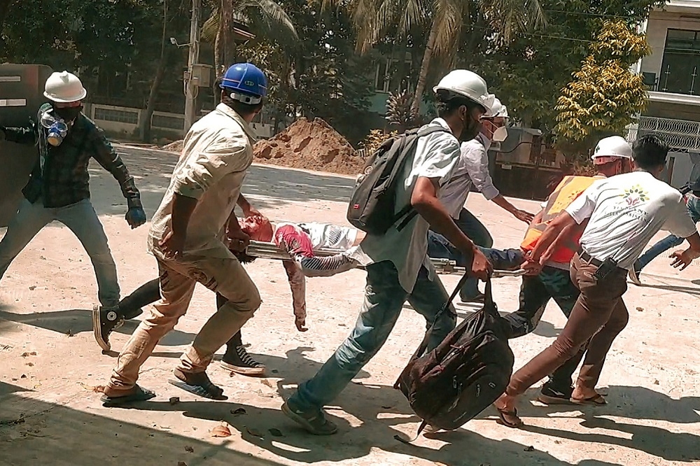 緬甸仰光北達貢區街頭民眾搬運傷者。（湯森路透）