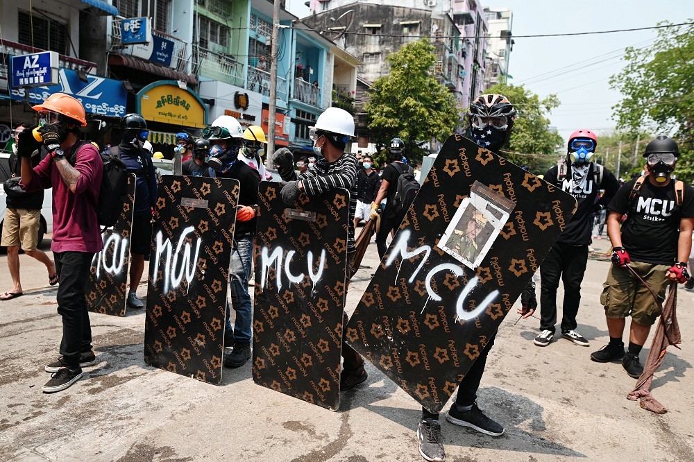 緬甸年輕人舉起自製盾牌上街抗議。（湯森路透）