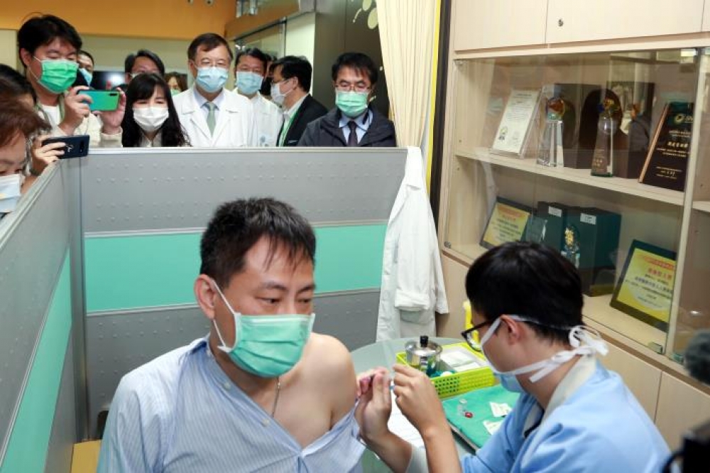 新冠肺炎疫苗雲嘉南第1針由台南奇美醫院感染科醫師蘇柏安接受施打，台南市長黃偉哲(後右一)親自關心醫護人員接種疫苗情況。(台南市政府提供)