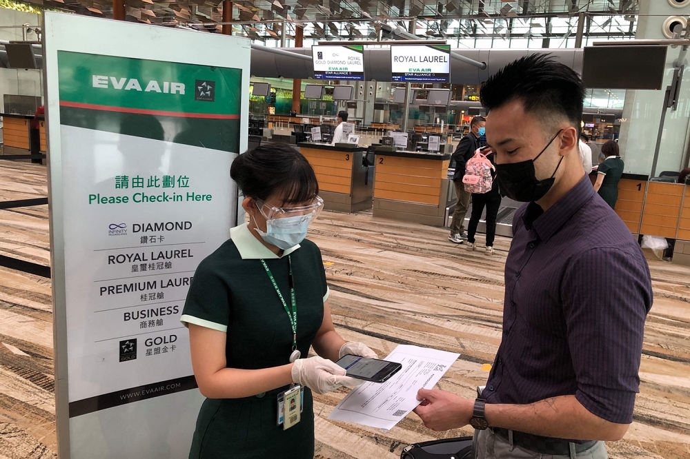 長榮航空由新加坡飛往台北的航班加入試行數位驗證平台，機場地勤人員掃描QR code後，即可迅速判讀旅客所持的醫療報告是否符合入境國的相關政策要求。（長榮航空提供）