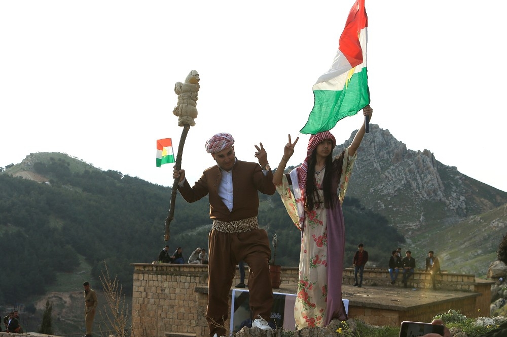 庫德年輕人高舉庫德自治區旗子慶祝新年。（湯森路透）