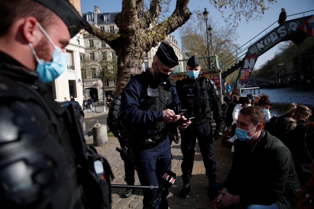 巴黎警方驅散人群，執行封城規定。（湯森路透）