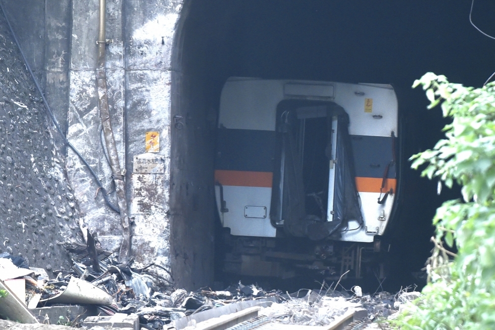 台鐵太魯閣號因工程車滑落撞擊出軌，第8節車廂首當其衝，目前仍卡在隧道，預計切割支解後拖出。（張哲偉攝）