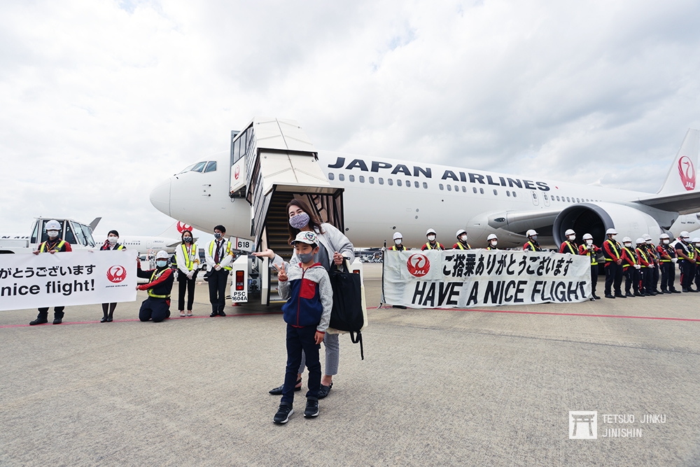 類出國包機吸引不少日本民眾參與，日本航空的地勤人員還特別持布條歡迎搭乘旅客。（陳威臣攝）