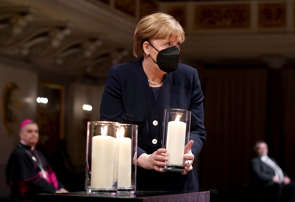 德國總理梅克爾於現場點蠟燭追念。（湯森路透）
