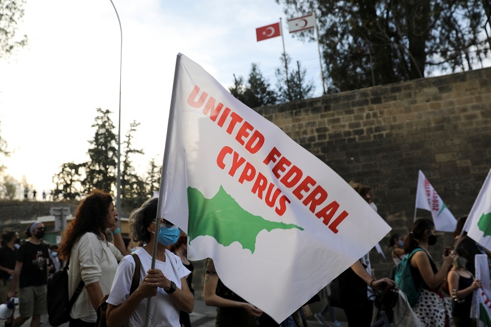 塞普勒斯民眾在首都尼古希亞高舉統一旗幟。（湯森路透）