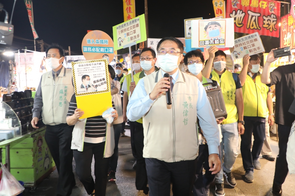 台南市長黃偉哲11日晚間走進大東夜市，透過廣播和一一走訪向民眾和攤商宣導保持社交距離及戴口罩。（台南市政府提供）