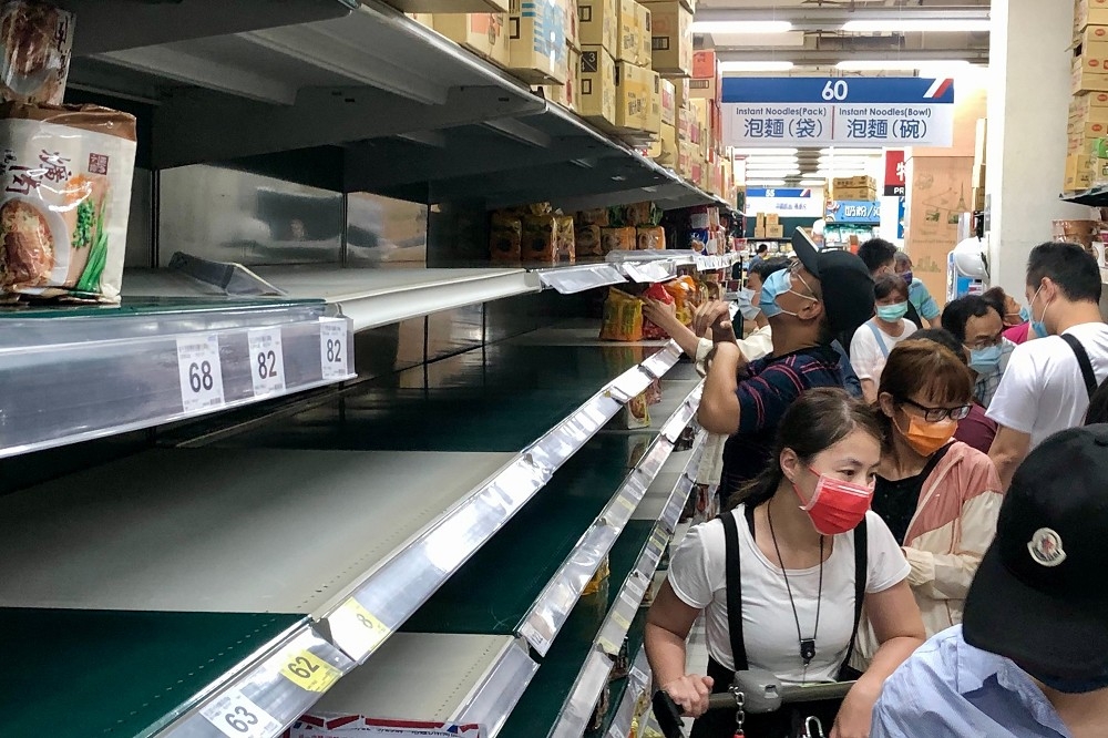 台北、新北市疫情警戒升至三級，大量民眾湧入賣場，搶購罐頭、泡麵等物資。（王侑聖攝）