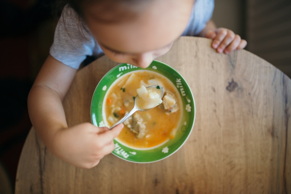 （取自 2020 © Nenad Stojkovic, A child eating vegetable soup from above. @ Flickr, CC BY-SA 2.0.）