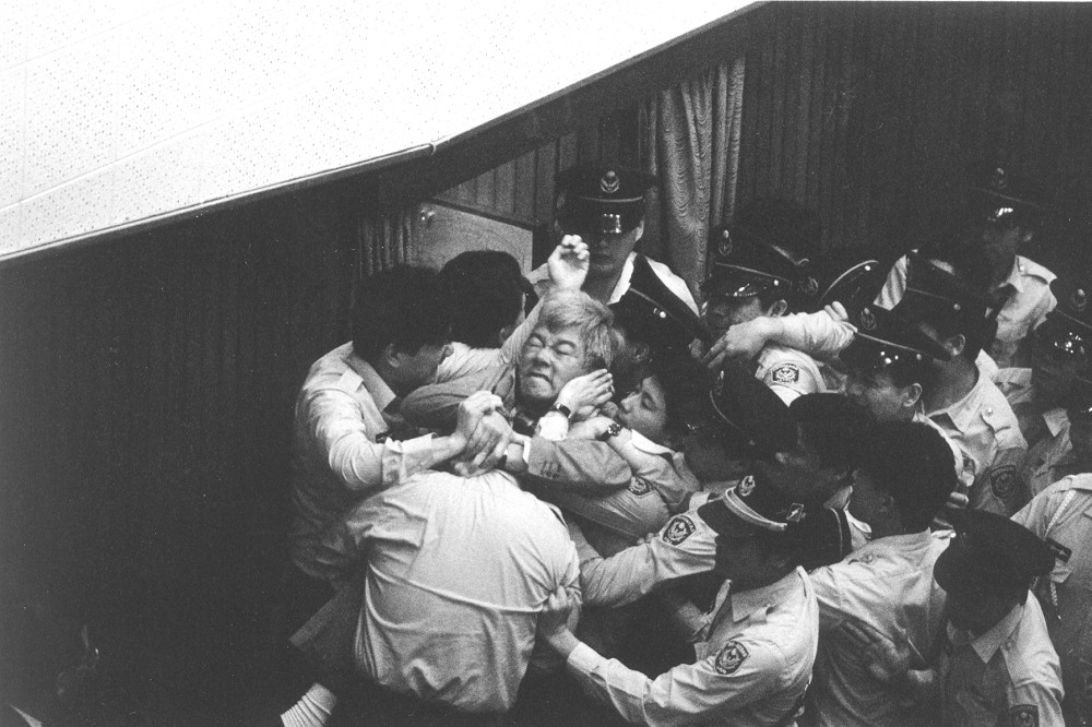 1991年4月12日立法院議場衝突中，盧修一被主席梁肅戎召來的駐衛警強制包圍至動彈不得。（潘小俠攝影，圖片由白鷺鷥文教基金會授權刊用）