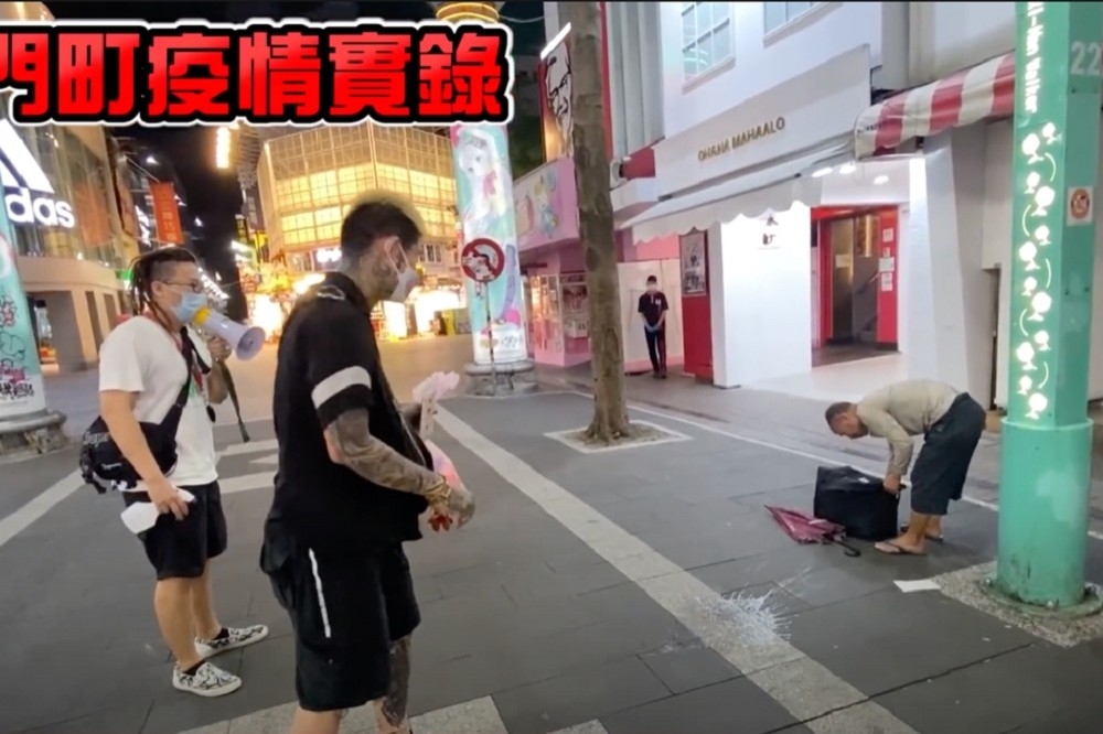 YouTube團體「大麻煩」在西門撞見一名沒戴口罩的街友，竟將自製「酒精水球」砸向街友周圍，引發爭議。（擷自大麻煩YouTube）