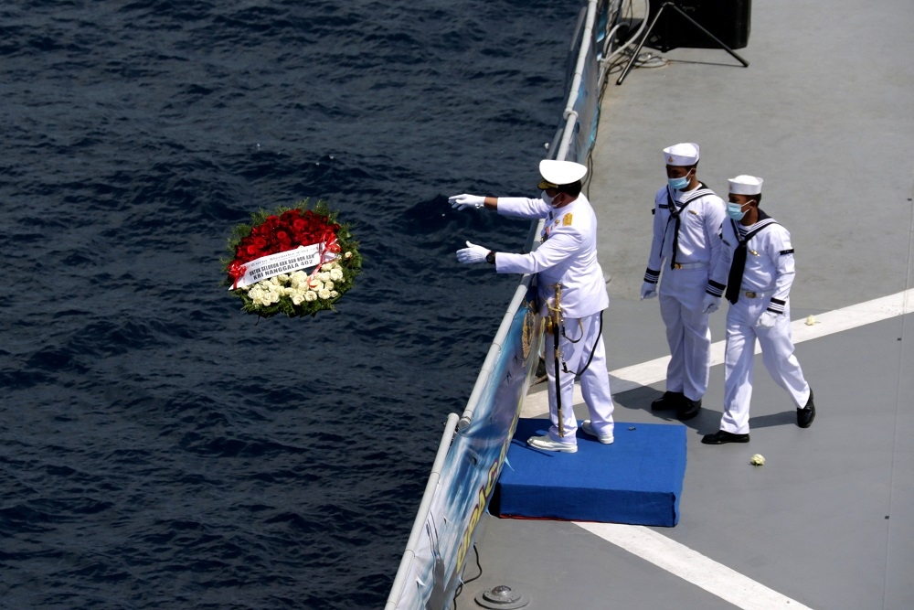 印尼海軍向海面投擲花圈悼念殉職官兵。（湯森路透）