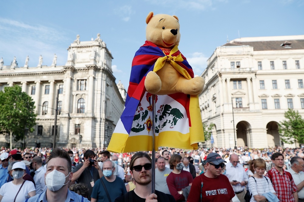 匈牙利民眾高舉象徵西藏流亡政府的「雪山獅子旗」與諷刺習近平的「小熊維尼」，表達對復旦大學設置海外分校的不滿。（湯森路透）