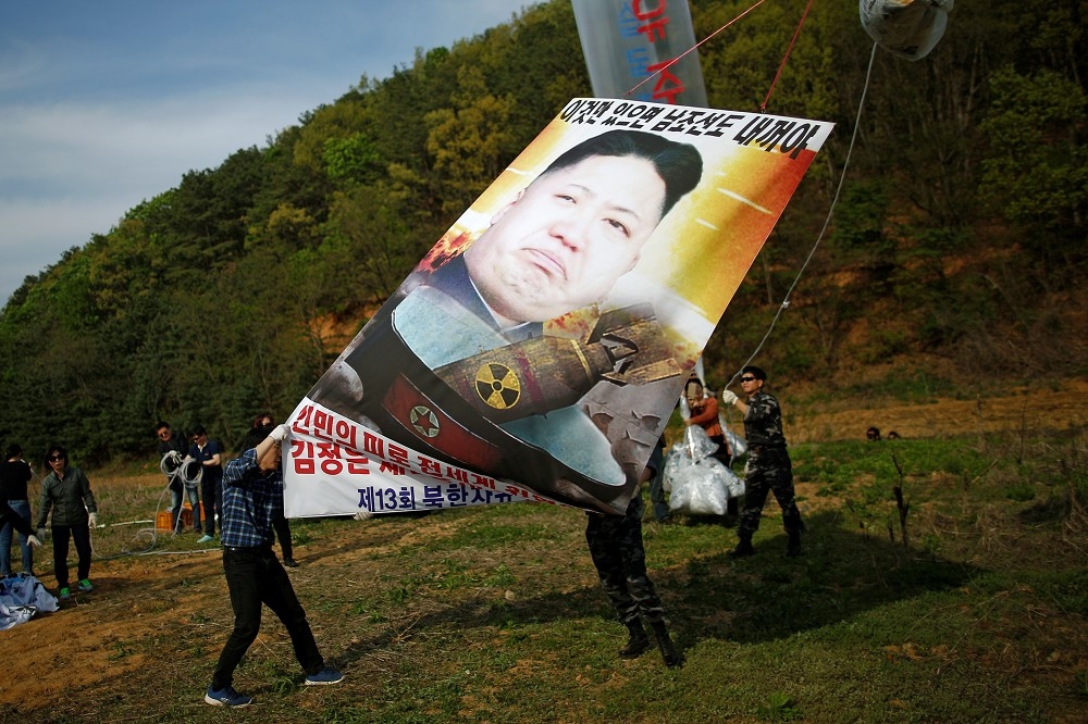 脫北者在南北韓非軍事區舉起反金正恩旗幟。（湯森路透）