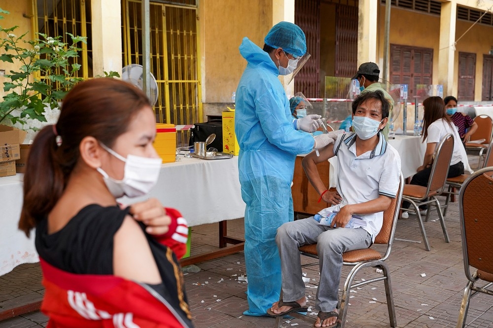 柬埔寨軍人正在幫金邊民眾施打疫苗。（湯森路透）