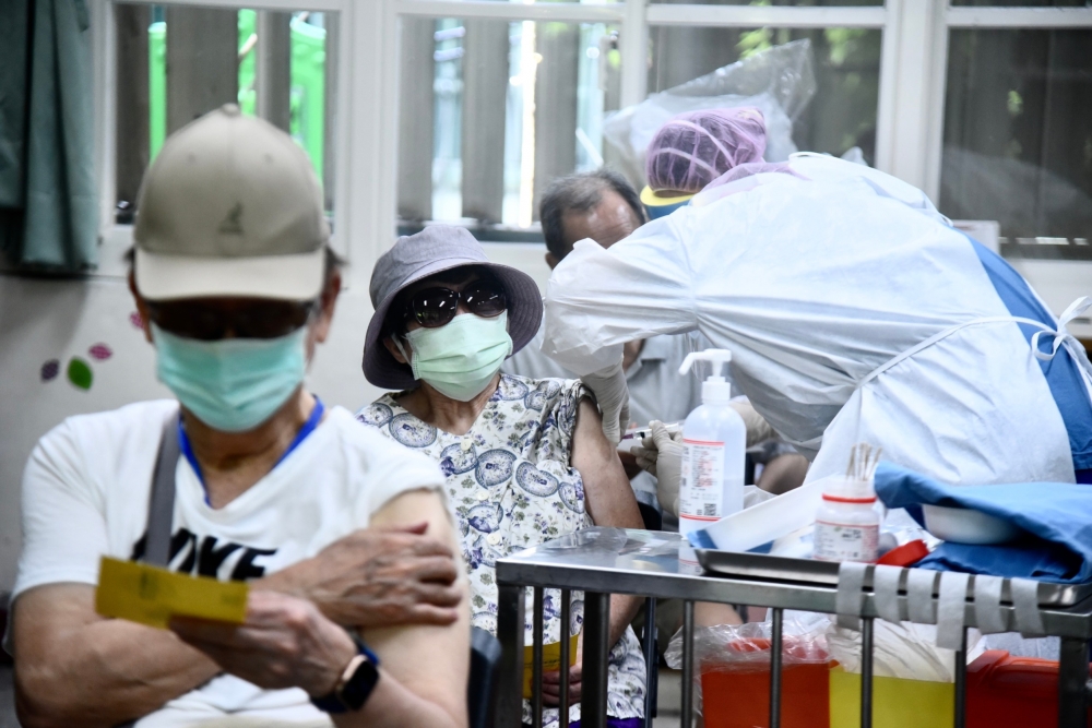 15日起擴大施打AZ疫苗，開打至今已有逾30位長者接種後猝死，讓緩打潮逐漸顯現。圖為民生國小接種站施打疫苗情形。（張哲偉攝）