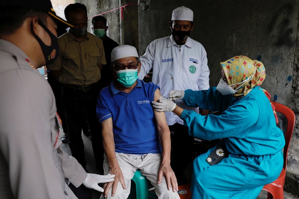 印尼醫護人員替偏遠地區民眾接種疫苗。（湯森路透）
