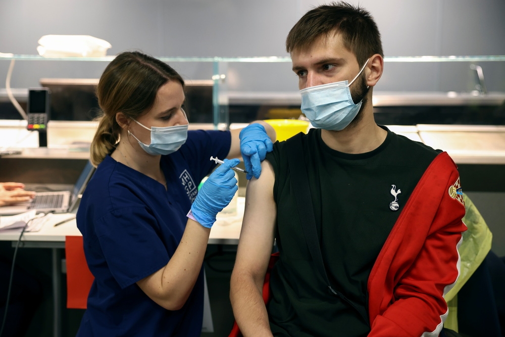 英國青年進行新冠疫苗接種。（湯森路透）