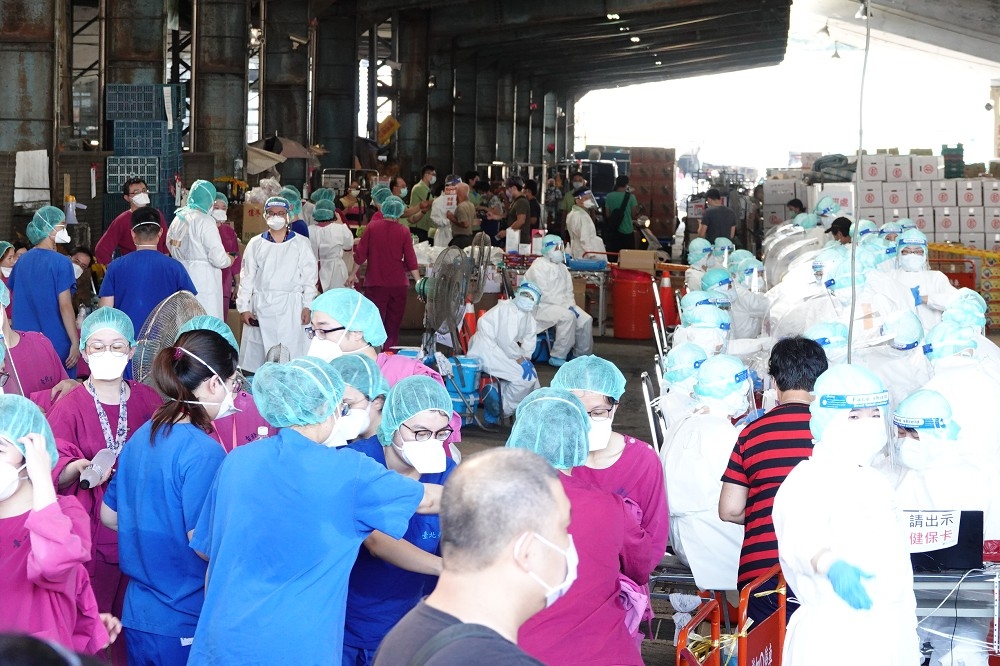 北市上午出動90名醫護到北農第一果菜市場，共設10個快篩櫃台，預估1小時篩檢400人次。（王侑聖攝）